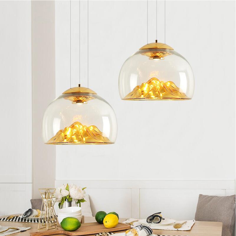 Transform your space with the Modern Electroplated Glass Pendant Lamp, a sophisticated lighting solution that blends contemporary design with artistic flair. Featuring a sleek, electroplated golden glass finish and a unique Nordic mountain-inspired design, this lamp adds a touch of elegance to any room. Crafted from high-quality glass and iron, it provides durable, energy-efficient lighting with included LED bulbs. The adjustable steel cables allow for customizable height, making it perfect for dining areas, living rooms, bedrooms, restaurants, hotels, or offices. Available in clear and golden or clear and silver finishes, this pendant lamp enhances any interior with style and functionality. Elevate your decor today!