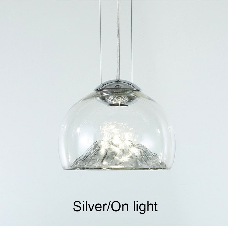 Transform your space with the Modern Electroplated Glass Pendant Lamp, a sophisticated lighting solution that blends contemporary design with artistic flair. Featuring a sleek, electroplated golden glass finish and a unique Nordic mountain-inspired design, this lamp adds a touch of elegance to any room. Crafted from high-quality glass and iron, it provides durable, energy-efficient lighting with included LED bulbs. The adjustable steel cables allow for customizable height, making it perfect for dining areas, living rooms, bedrooms, restaurants, hotels, or offices. Available in clear and golden or clear and silver finishes, this pendant lamp enhances any interior with style and functionality. Elevate your decor today!